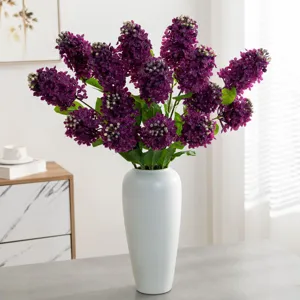 Kunstmatige paarse sering bloemenboeket in witte vaas voor woonkamer tafeldecoratie.