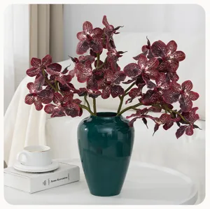 Artificial Phalaenopsis orchid floral arrangement detail view in green ceramic vase for home decor.