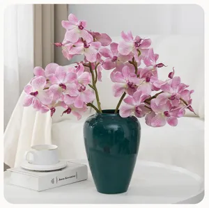 Artificial Phalaenopsis orchid floral arrangement in dark green vase for home decor wedding.