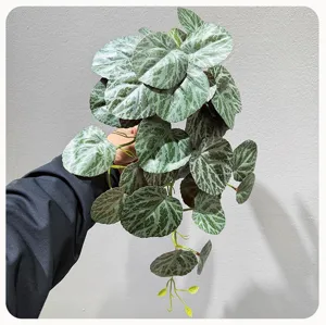 Detail view of artificial hanging plant foliage with unique patterned leaves for wall decor.