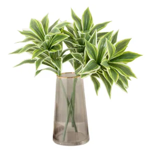Artificial dracaena plant in grey glass vase for indoor home and office decor display.