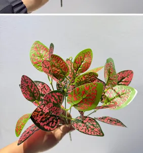 Vista detallada de hojas de plantas artificiales, follaje verde y rosa para decoración.