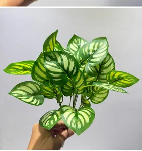 Vista detallada de hojas de plantas verdes artificiales, follaje decorativo para el hogar.