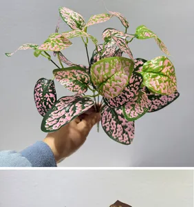 Primer plano de ramas de plantas artificiales con hojas matizadas en rosa y verde para decoración.