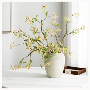 Dettaglio ramo di fiori artificiali, composizione floreale decorazione casa in vaso ceramica.