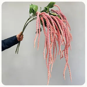 Close-up detail of artificial hanging pink amaranth flower hand-held for wedding decor.