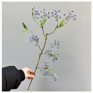 Vista di dettaglio di un singolo ramo di fiori artificiali viola, con steli naturali.