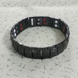 Detail shot of black magnetic link bracelet with red and white energy stones structure.