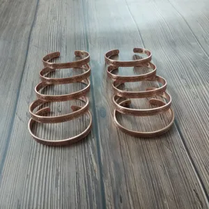 Vista di dettaglio del bracciale rigido magnetico in rame puro con motivo floreale vintage.