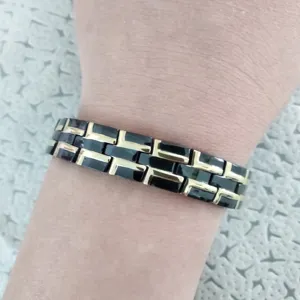 Detail view of the black and gold titanium steel magnetic bracelet, showcasing the link design.