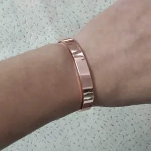 Detail view of the 8mm wide magnetic copper cuff bracelet worn comfortably on a woman's wrist.