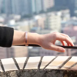 Copper magnetic bracelet detail shot, adjustable open cuff design with elegant braided pattern.