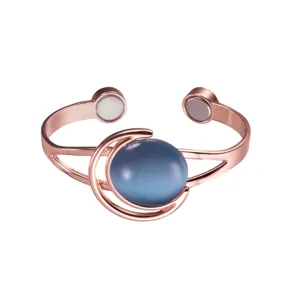Rose gold magnetic copper bracelet detail showing blue synthetic stone and moon design.