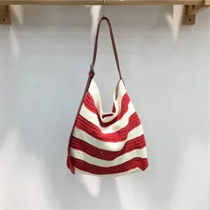 Detailed view of a red and white striped knit hobo shoulder bag hanging nicely.
