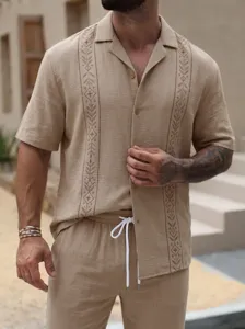 Detail view of men's casual beige short sleeve shirt and trousers set with embroidered front.