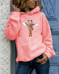 Close-up detail view of the adorable giraffe floral print on the soft coral pink hoodie.