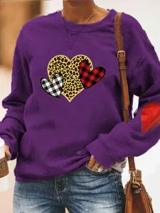 Close up detail of the purple fleece sweatshirt featuring cute heart print and sleeve patch.