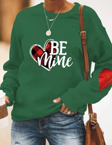 Vista detallada de la sudadera verde de San Valentín con diseño de corazón Be Mine y parche en codo.