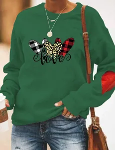 Green sweatshirt sleeve detail showing heart patch, casual long sleeve pullover fashion.