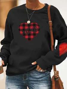 Sweat-shirt noir manches longues avec motif cœur à carreaux rouges et col rond stylé.