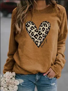Detail shot of the casual camel crewneck sweatshirt featuring a chic leopard heart print.