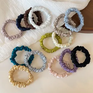 Detailed view of assorted colored silk satin hair scrunchies, elegant small hair ties for ponytails.