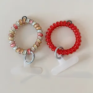 Colorful coiled phone wrist strap and mobile tether tab set for secure everyday carrying.