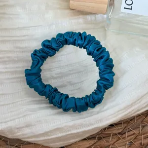 Dark blue silk satin hair scrunchie, elegant small hair tie for ponytail and hair styling detail shot.