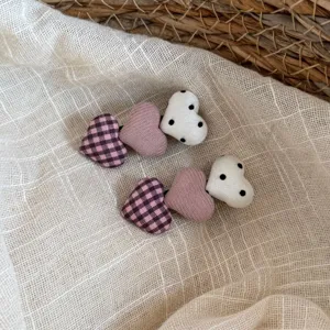 Primer plano detallado de bonitos pasadores de tela con diseño de corazones y lunares.