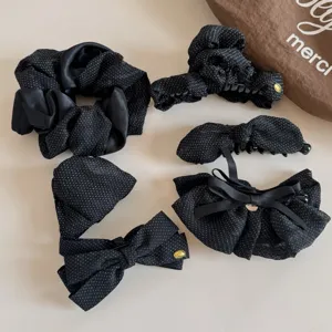 Detail view of black polka dot hair scrunchies and stylish bow claw clips set for daily wear.