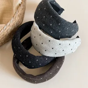 Détail en gros plan de serre-têtes larges en laine douce avec motifs de cœurs mignons, tendance automne.