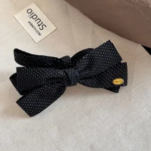 Black polka dot bow hair clip detailed close up view showcasing elegant texture for daily look