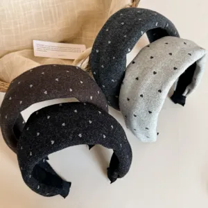 Vue détaillée de serre-têtes en laine rembourrés avec des cœurs. Accessoire hivernal doux.