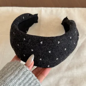 Vue détaillée du serre-tête large en laine noire avec coeurs argentés, accessoire cheveux.