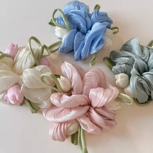Gedetailleerd overzicht van de parelmoeren gaas tulp haarscrunchie met zacht bloemendesign.