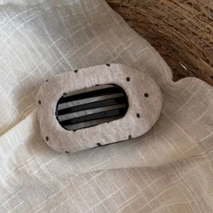 Gros plan d'une pince à cheveux plate en tissu à pois de style coréen pour coiffures.