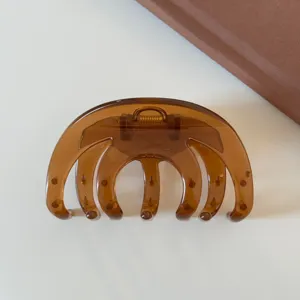 Pinza per capelli trasparente marrone accessorio elegante versatile per donne quotidiano.
