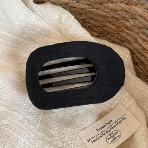 Barrette en tissu noir au design rayé large, accessoire élégant et polyvalent pour femmes.