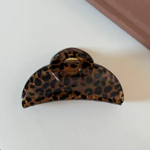 Dettaglio molletta per capelli maculata, elegante fermaglio marrone per acconciature quotidiane donna.