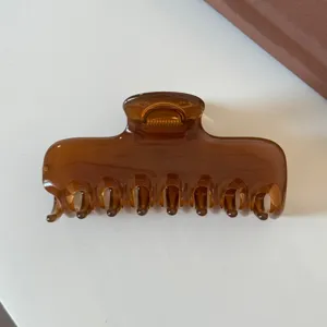 Primo piano dettagliato di un elegante fermaglio per capelli marrone con finitura lucida.
