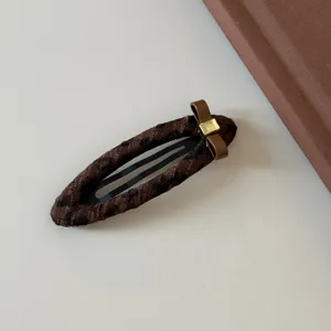 Horquilla de pelo marrón con estampado de leopardo, lazo y detalle dorado elegante.