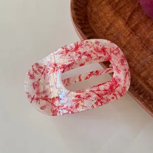 Molletta per capelli piatta in acetato con motivo rosso e bianco, accessorio elegante dettaglio.