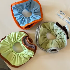 Creative zippered fabric hair scrunchies in colorful designs, stylish daily styling accessory.