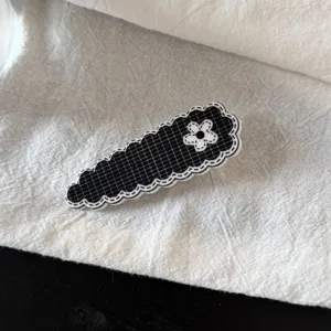 Jolie pince à cheveux à carreaux noir et blanc avec un motif de fleur mignon et tendance.