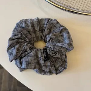 Primo piano dettagliato di elastico per capelli in tessuto a quadri grigio scuro accessorio