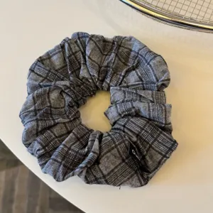 Elastico per capelli a quadri grigio scuro, dettaglio del tessuto, elegante accessorio quotidiano.