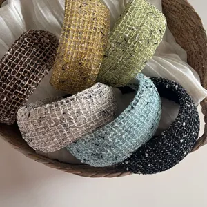 Closeup detail of colorful woven mesh headbands in a basket, stylish textured hair hoop accessory