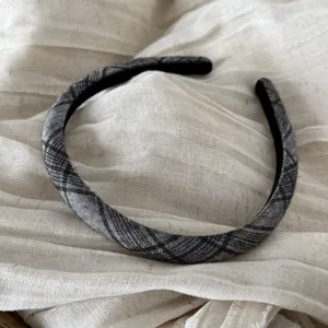 Vista dettagliata di un elegante cerchietto in tessuto a quadri nero e grigio quotidiano.