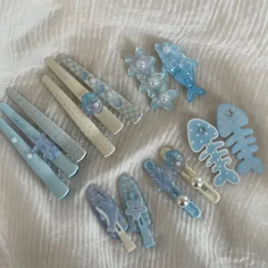 Detailed view of cute blue ocean-themed hair clips, featuring starfishes and dolphins.