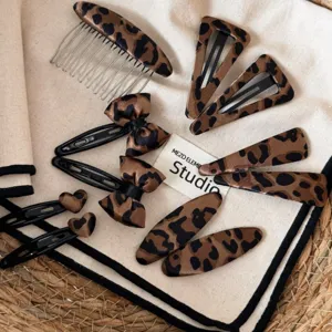 Vista detallada de pinzas para el cabello y peine con estampado de leopardo vintage.
